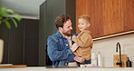 Dance, love and dad with baby in kitchen for happy, celebration and bonding. Playful, movement and music with man and child in family home for support, weekend and holding hands for entertainment