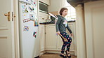 Costume, dancing and girl with smile in kitchen, creative expression and playing for development. Childhood, spoon and child with fantasy dress up for imagination growth, home and moving to music