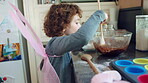 Girl, butterfly wings and baking in kitchen, development and learn culinary skills with ingredients. Child, growth and kid with creative costume, cooking and dessert preparation with recipe in house