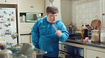Child, teenager and singing with spoon in kitchen for fun, imaginary karaoke and talent show. Pop star, kid and mic with utensil for sing along, vocal performance and boy with down syndrome in home