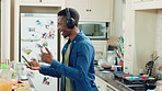 Man, dance and headphones in home with phone, feel good energy or listen to music on weekend break. Happy, black person and streaming playlist in kitchen with audio tech, wellness or movement to song