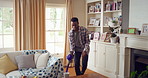 Happy, man and vacuum in living room with dance, household chores and listen to music on weekend. Black person, appliance and streaming playlist in home with housekeeping, clean and movement to song.