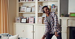 Man, dance and headphones in lounge with smile, feel good energy or listen to music on weekend break. Happy, black person and streaming playlist in home with audio tech, wellness or movement to song.