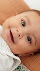 Face, baby or happy with toy in home for early childhood development or growth on blanket above. Portrait, top view or cute infant with smile or playing on bed for comfort or entertainment in nursery