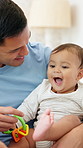 Dad, baby or child with toy for development, learning and growth in family home. Toddler, infant kid and father or single parent with love, care and security for mobility and playing in bedroom