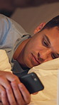 Night, man and fatigue in bed with phone, scroll and check social media for online entertainment. Late, exhausted person and typing in home with digital tech, mobile app or text message notification.