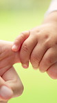 Baby, parent or hand with finger grip in nature for bonding, comfort or early childhood development. Closeup, guardian or toddler with touch, love or care for motor skills, security or protection