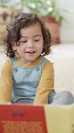 Smile, child and relax with reading book at house for education, fairytale story and learning. Toddler, girl and fiction novel for storytelling, language development and knowledge in living room