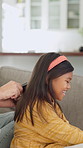 Brushing, hair and hands with child, home and bonding with girl on couch and routine in living room. Happy, kid and haircare for daughter with hairbrush, grooming and change of hairstyle in house