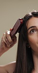 Woman, hair and grooming with brush for haircare, treatment or styling on a studio background. Female person, salon or cleaning with beauty tool for straight hairstyle, smooth texture or volume