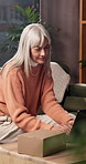 Laptop, box and woman on sofa in home with positive review for ecommerce, delivery or online order. Computer, happy and mature person in living room with feedback on website for cardboard package.
