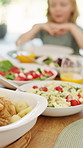 Food, feast and child at dining table for lunch, healthy meal and cuisine selection for nutrition. Weekend buffet, vegetables and girl with balanced diet for wellness, family home and homemade dish