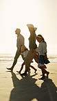 Parents, children and holding hands on beach with sunset, summer holiday or walk for bonding together. Happy people, mother and father by ocean with girl kids, family vacation and support for travel.