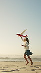 Happy, girl or running with aeroplane on beach for summer holiday, weekend or outdoor vacation. Playful, child or kid playing with flying toy or waves on ocean coast for childhood or travel on space