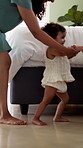 First steps, milestone and walking with in home with mother, toddler and development or growth. Balance, learning or support with mom, woman and excited child in house for motor skills or movement