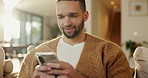 Phone, relax and happy man in home for online response, social media or check profile at living room. Mobile, sofa and person with app for communication on forum, smile or post update with message