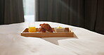 Morning, breakfast and croissant on bed in hotel, juice and healthy food with nutrition on vacation. Bedroom, room service and catering for weekend getaway, hospitality and holiday accommodation
