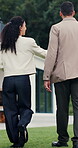 Walking, client and real estate agent with backyard tour for property features, assessment or sale. Back, realtor and man in discussion outdoor for private viewing, house inspection and information