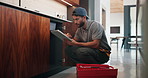 Fixing, sink and man with tablet in kitchen, typing or damage inspection of drainage system in house. Serious, handyman and pipe improvement with tools, scroll and quality assurance with tech in home