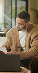 Paperwork, reading and man with laptop for remote work, data entry and audit records for bookkeeping. Review, info evaluation or freelancer with computer to transcribe documents, home or check report