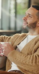 Happy, man and smell coffee in living room with aroma, morning reflection and relax for weekend break. Person, smile and thinking in house with fragrance tea, drink scent and peace for wellness.