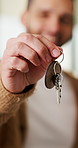 Man, hand and moving in new home with key, property investment or mortgage loan for real estate goal. Person, keychain or homeowner in dream house with security, achievement or success for relocation