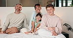 Face, parents and kids relax in bedroom for bonding, holiday and happiness in family home. Mother, father and children with smile, comfort and hug for weekend, connection and wellness in portrait