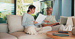 Couple, documents and discussion with laptop on sofa for financial success or investment in home. Man, woman or paperwork with computer for finance, budget planning or expenses together in house