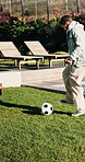 Teenager, playing and ball in backyard for soccer fitness, practice juggling and footwork skills. Active, boy and freestyle training for football tricks, sports activity and weekend hobby at house