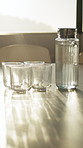 Jug, water and glasses on table in office for hydration, health and wellness in meeting room. Break, refreshment and pitcher with cup for beverage or drink on desk in empty boardroom at workplace.