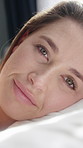 Happy, bed and face of woman on pillow for comfortable, cozy and resting on weekend in home. Morning, relax and portrait of person in bedroom, blink and wake up for calm, peaceful and wellness