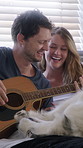 Laugh, couple and guitar in home with dog, conversation and bonding together on weekend break. Pet, man and woman with acoustic instrument to play music, funny husky and love for connection in house