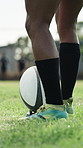 Rugby, legs and person with ball on tee for practice, game training or kick preparation at field. Sports, shoes or man getting ready with equipment at pitch for exercise, match or competition outdoor