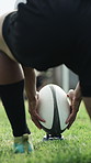 Rugby, hands and person with ball placement for practice, game training and competition preparation. Sports, legs or man positioning equipment at pitch for exercise, match and back with shoes outdoor