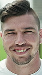 Face, happy and man on soccer field for exercise, training and match practice for tournament. Portrait, smile and fitness with male person for football, sports challenge and confident for competition