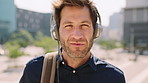 Face, man and headphones in city with commute, streaming music and pride for real estate agent career. Realtor, person and audio tech in urban town with podcast, online radio and travel for work.
