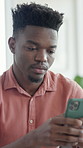 Texting, online and man with phone, house and internet search on social media, serious and thinking. Typing, message and black person with decision, reflection and communication on mobile in home