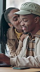 Date, laptop and black couple in cafe for talking, conversation and bonding on coffee break. Kiss, restaurant and man with woman with drink, beverage and computer for relationship, love and support