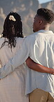 Hug, black couple and walk on vacation at beach for honeymoon trip, conversation and bonding. Back, happy people or embrace at seaside for romantic stroll, healthy relationship or anniversary getaway