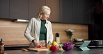 Vegetables, cooking and senior woman with tablet, online recipe and instructions for meal prep. Kitchen, internet and person cutting ingredients on tech for food blog, website and culinary video