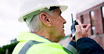 Conversation, man and radio on construction site for task brief, inspection or safety update. Industrial, planning and mature engineer with tech, progress report or project coordination for feedback