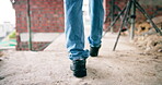 Construction, walk or legs on site with inspection, safety check or quality control in building project. Back, man or engineer with renovation, progress track or evaluation in industrial compliance.
