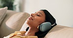 Headphones, relax and woman on sofa in home with music, playlist or podcast online in lounge. Calm, audio tech and female person chilling with streaming of album on weekend in living room at house.