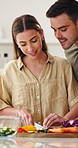 Vegetables, smile and couple in kitchen with cooking for dinner, meal or healthy diet together. Food, bonding and man with woman for cutting ingredients for preparing supper with nutrition in house.