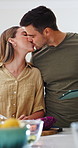 Couple, kiss and cooking with tablet in kitchen, bonding or learning culinary skills on social media. Meal prep, home and happy people with tech, discussion and recipe tips on website and research