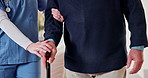 Caregiver, hands and old man in nursing home with cane, support and help for injury rehabilitation. Nurse, walking stick and senior person with disability, assistance or healing in retirement center.