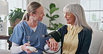 Consultation, blood pressure and nurse with senior woman for homecare with hypertension diagnosis. Sphygmomanometer, medical checkup and caregiver with elderly patient for cardiology exam in house.
