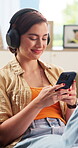 Headphones, phone and woman on sofa for music, online streaming and radio on app for weekend. Home, happy and person on cellphone for connection, internet podcast and playlist to relax on break