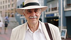 Old man, face and happy for travel in city with hat, tourism and sightseeing on holiday in retirement. Senior person, portrait and vacation with bag, smile outdoor or confidence on trip in urban town