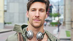 City, tourist and face of man with headphones, bag and commute for travel, holiday or weekend abroad. Outdoor, tourism and portrait of person in town for vacation, sightseeing and trip in Germany